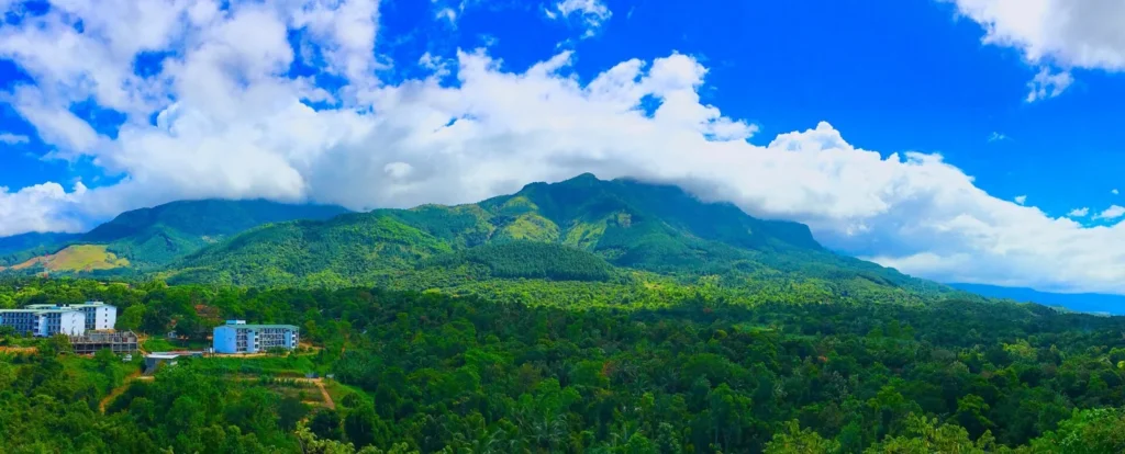 Panoramic green mountain landscape with forest, buildings and low clouds at Belihuloya, Sri Lanka