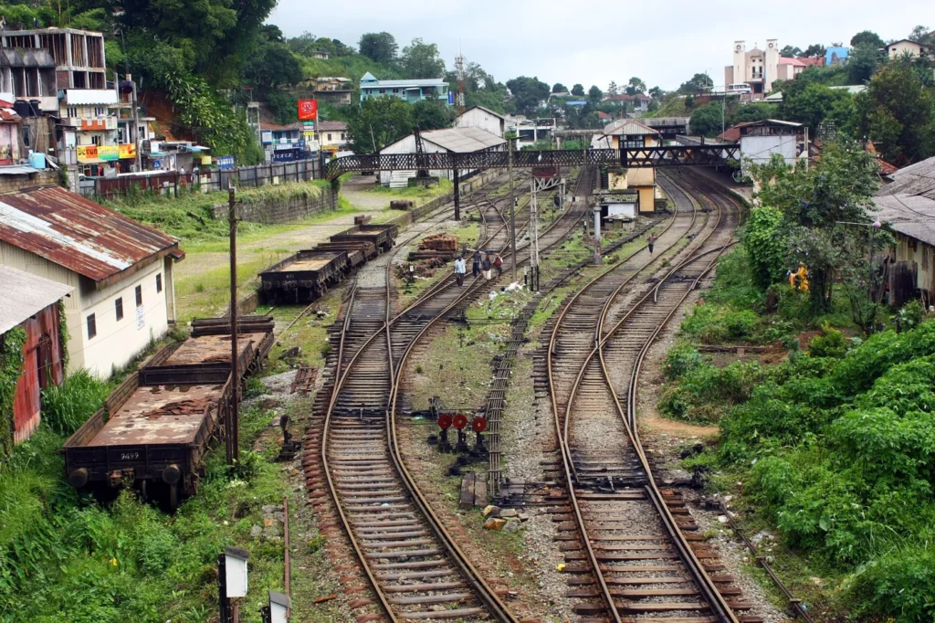 Railway tracks curving through Hatton station with platforms and hillside town buildings, Sri Lanka