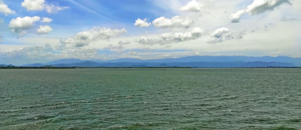 Udawalawe Reservoir landscape Open water of Udawalawe Reservoir with distant hills beneath a cloudy blue sky, Sri Lanka